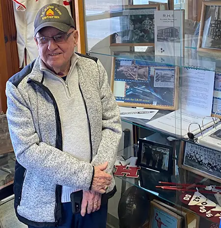 Bob Comer standing by a display case in the history museum